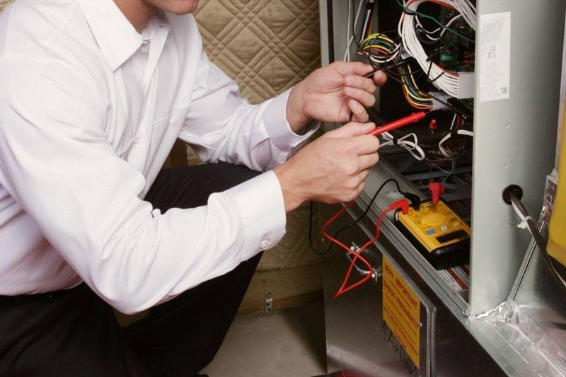 HVAC technician performing maintenance on a furnace