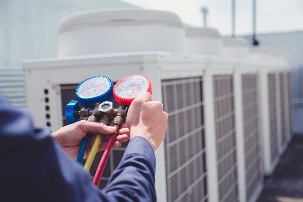 HVAC tech checking on commercial HVAC system on roof